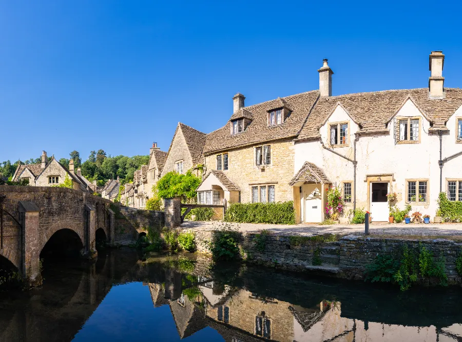 A row of stone cottages alongside a stream in an English village — heritage stock waiting for sensitive regeneration.